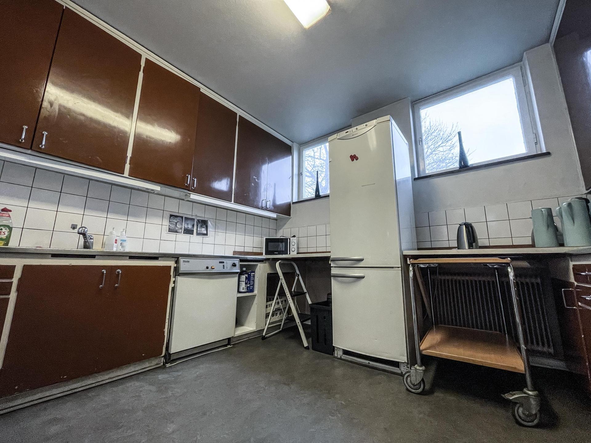 Köket — Ett kök av äldre snitt finns i anslutning till kapprummet. Kaffebryggare, restaurangdiskmaskin (snabb), och kyl/frys. Här finns även städskåpet.