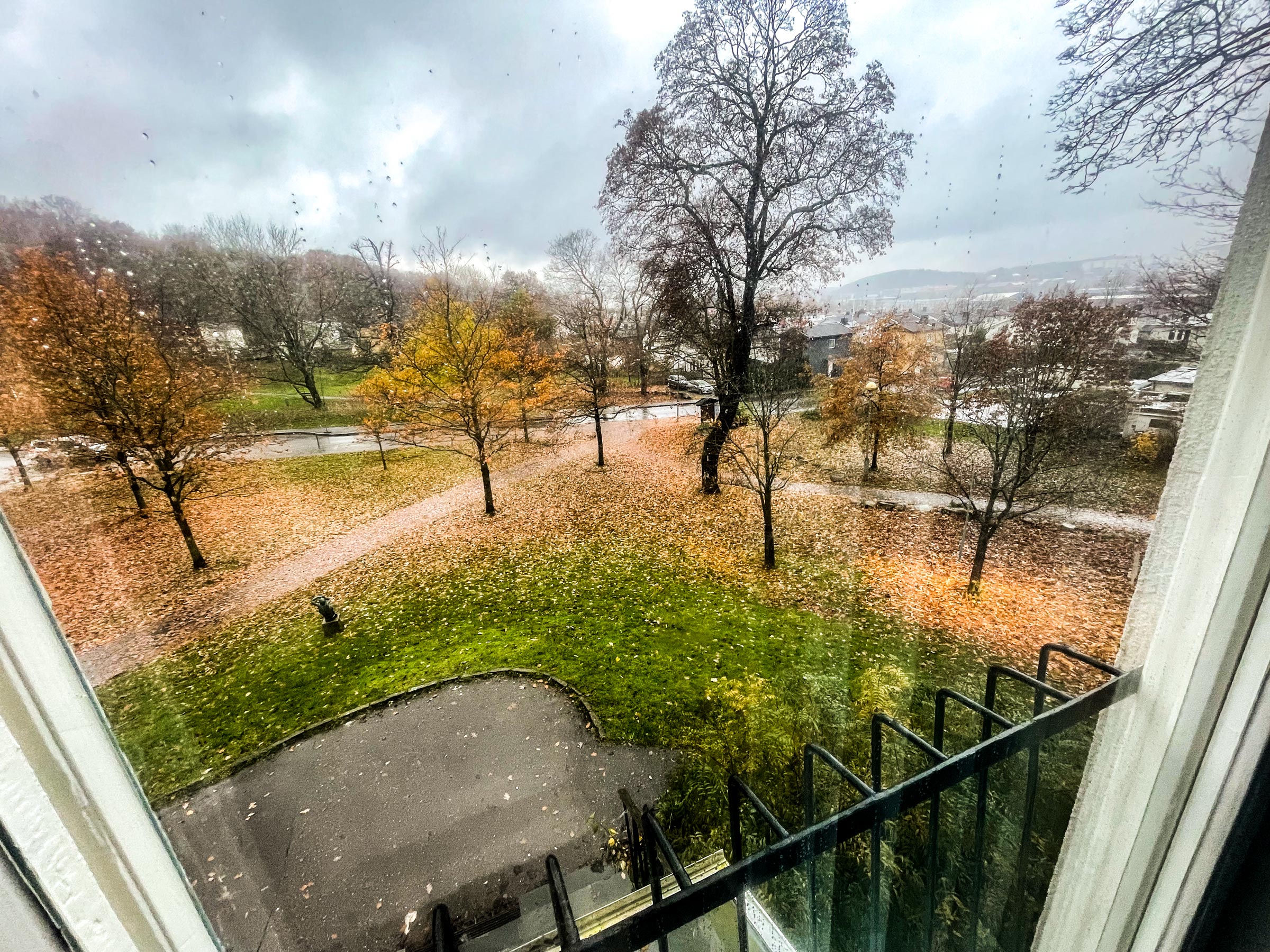 Vy mot parkeringen och västra parken — Det finns gott om plats för bilar vid parkeringen. Parken fortsätter västerut och upp i skogen vid Valåsen.